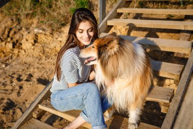 Collie köpek ile yürüyen genç güzel kadın.