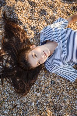 Kumlu sahilde oturan genç güzel güzel kız.