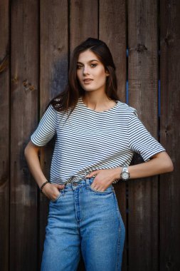 Genç kız ahşap duvar yakınındaki moda
