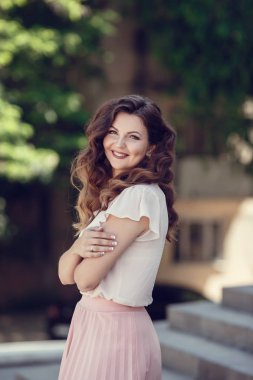 Şehirde poz fotoğraf makinesi bakarak mükemmel saçlı güzel genç modeli kadın