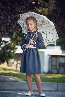 Okul üniforması charming kız sabah şehirde yürüyor