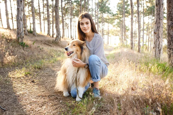 Junge schöne Frau geht mit Collie-Hund spazieren. — Stockfoto