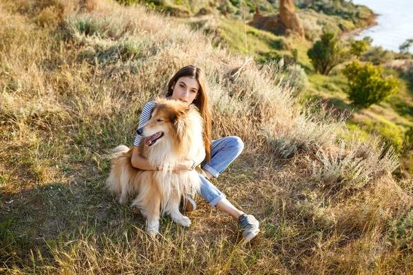 Mooie jongedame met collie hond wandelen. — Stockfoto