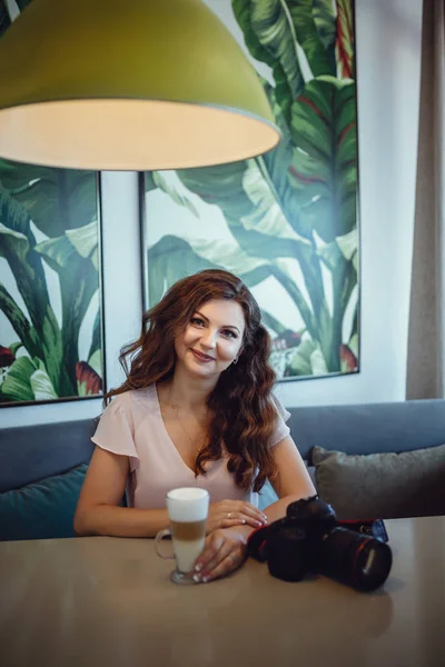 Hübsche junge Frau sitzt in einem Café mit einer Tasse Kaffee Latte — Stockfoto