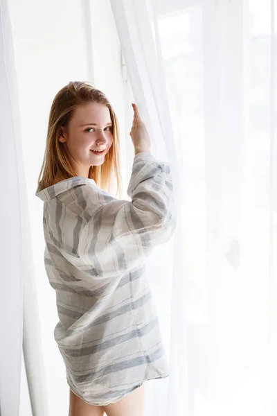 Mooie jonge vrouw in modern appartement stretching na wakker worden — Stockfoto