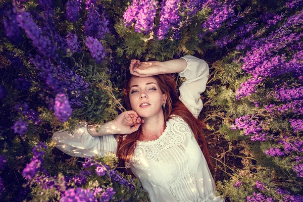 Mooie vrouw op paarse achtergrond. vrouw met paarse bloemen — Stockfoto