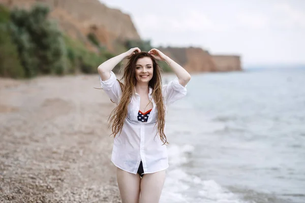 Nő a fehér ruhát frissítő a tengerparton — Stock Fotó