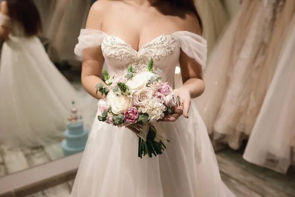 Bukett innehav av bruden hon bära vit brudklänning bröllop Shop — Stockfoto