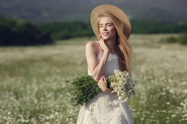 Vacker kvinna njuter fält av våren Daisy — Stockfoto