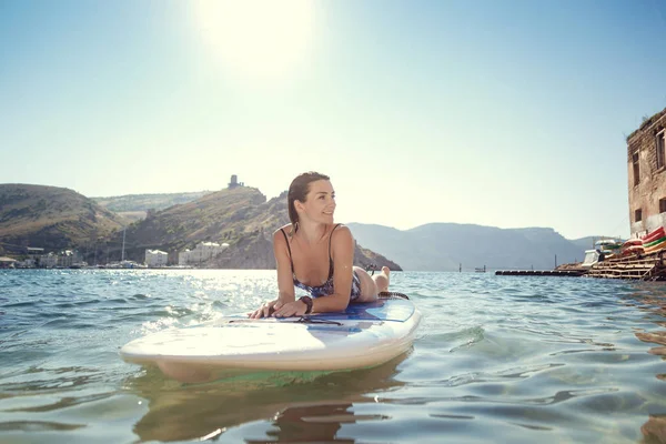 Joven atractiva mujer en SUP en las aguas azules — Foto de Stock