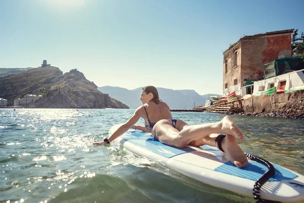 Joven atractiva mujer en SUP en las aguas azules — Foto de Stock