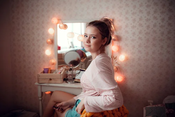Ładna dziewczyna patrzy na siebie w lustrze, pokoju światło. — Zdjęcie stockowe
