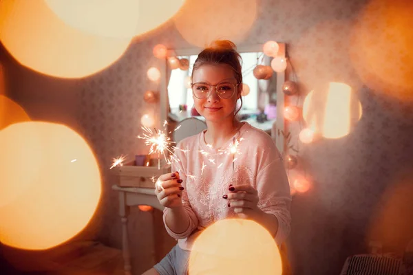 Jovem mulher alegre em suéter segurando sparklers . — Fotografia de Stock