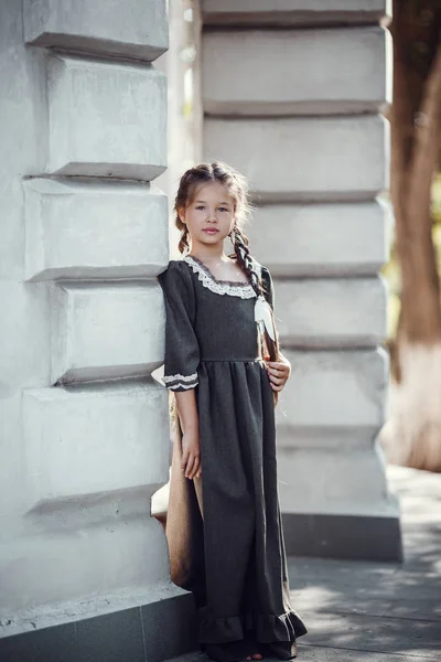 Belle petite fille dans une vieille robe sur le fond de l'architecture du centre historique — Photo