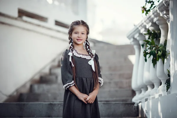 Piękna dziewczynka w starej sukni na tle architektury zabytkowego centrum — Zdjęcie stockowe
