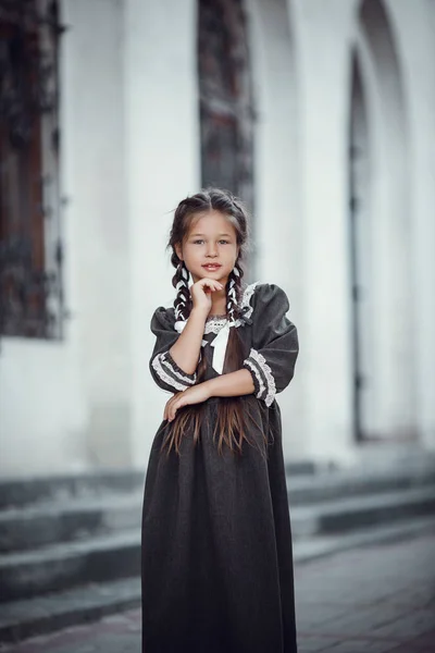 Menina bonita em um vestido velho no fundo da arquitetura do centro histórico — Fotografia de Stock