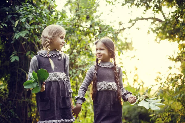 Deux petites sœurs heureuses aiment et se câlinent dans un beau parc — Photo