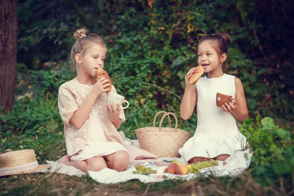 Deux petites sœurs heureuses aiment et se câlinent dans un beau parc — Photo