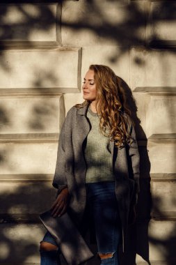 Moda modeli giyen sökük erkek kot pantolon, ceket ve spor ayakkabıları şehirde poz