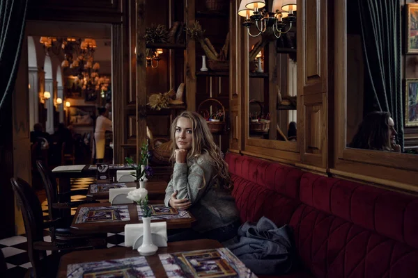 Portrait of a young woman in the interior of the restaurant at the table — Stock Photo, Image