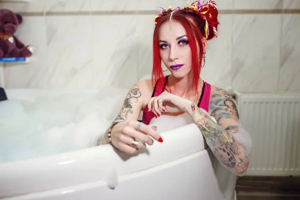 Modell wie eine Puppe mit Farbhörer liegt im Badezimmer, in der Badewanne. — Stockfoto