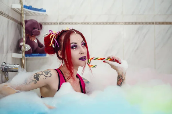 Modell wie eine Puppe mit Farbhörer liegt im Badezimmer, in der Badewanne. — Stockfoto