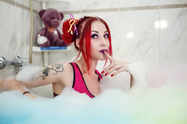 Modell wie eine Puppe mit Farbhörer liegt im Badezimmer, in der Badewanne. — Stockfoto