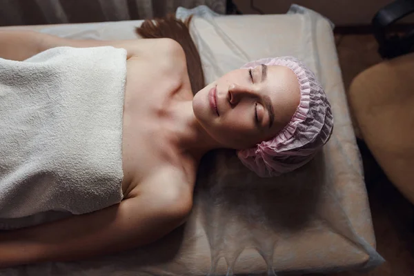 Cosmetología sala, esteticista hace masaje facial a una joven hermosa chica — Foto de Stock
