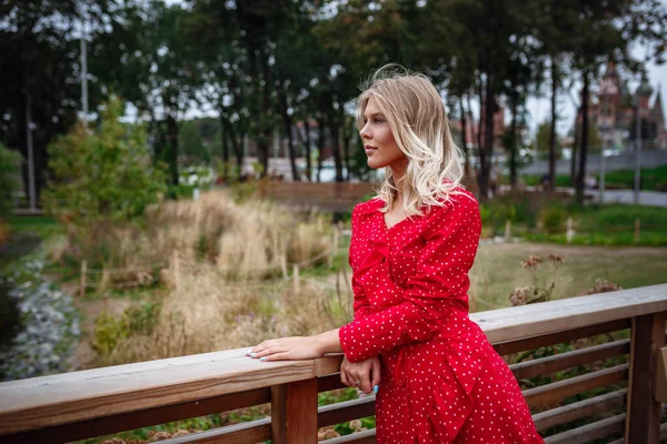 A beautiful young blonde woman walks in the center of Moscow.