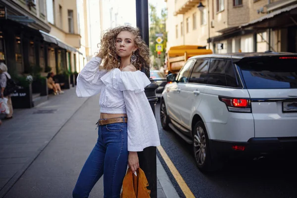 Una bella giovane donna con i capelli biondi ricci cammina attraverso il — Foto Stock