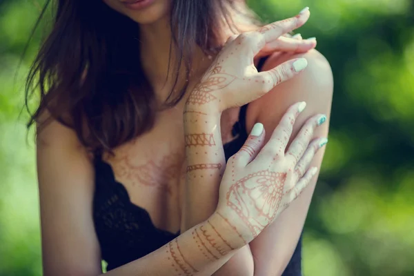 El dibujo mehndi por medio de la henna a las manos y la espalda de la muchacha —  Fotos de Stock