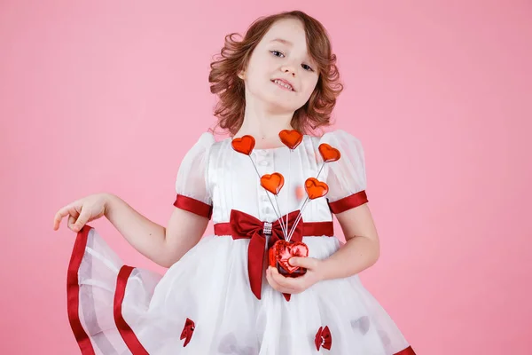 Retrato de menina bonito de pé em vestido branco com donuts ou coração de vidro — Fotografia de Stock