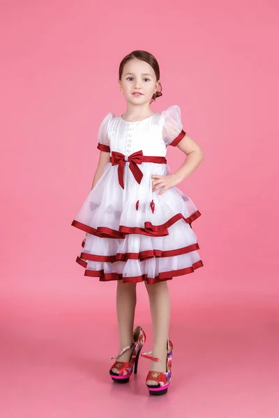 डोनट या ग्लास हार्ट के साथ सफेद पोशाक में खड़े प्यारी छोटी लड़की का चित्र — स्टॉक फ़ोटो, इमेज