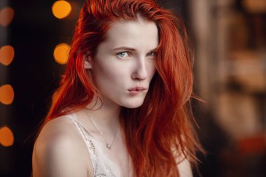 Dinleniyor. Ahşap odada poz katta seksi bir kızıl kız Portresi.