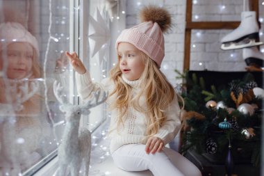 Bir pencere pervazına üzerinde oturan küçük kız