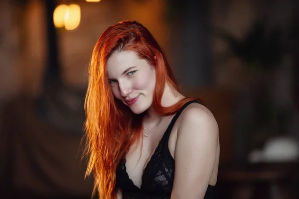 Ausruhen. Porträt eines sexy rothaarigen Mädchens auf dem Boden, das im Holzzimmer posiert. — Stockfoto