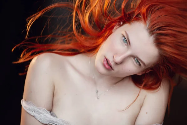 Having a rest. Portrait of a sexy redhead girl on the floor posing in the wooden room. — Stock Photo, Image