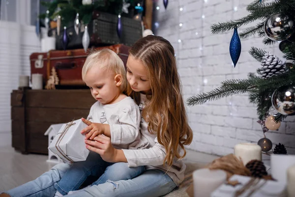 Niños bajo el árbol de Navidad con cajas de regalo. Las decoraciones de Año Nuevo . —  Fotos de Stock