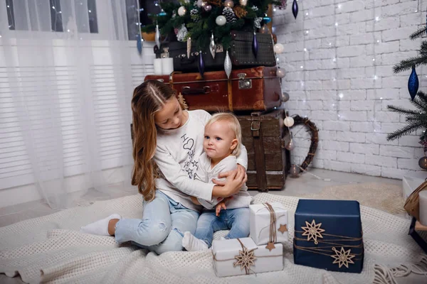 Bambini sotto l'albero di Natale con scatole regalo. Le decorazioni di anno nuovo . — Foto Stock