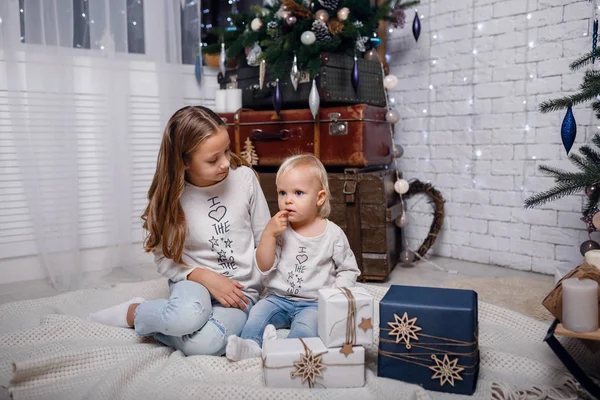 Bambini sotto l'albero di Natale con scatole regalo. Le decorazioni di anno nuovo . — Foto Stock
