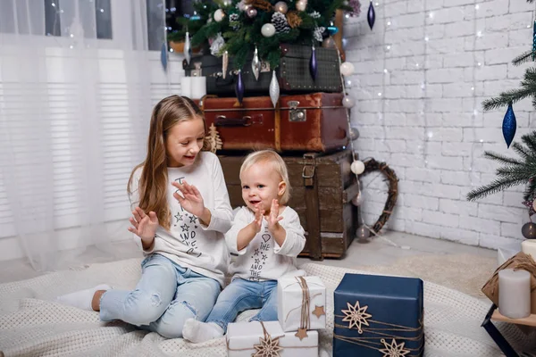 Crianças debaixo da árvore de Natal com caixas de presente. Decorações de Ano Novo . — Fotografia de Stock