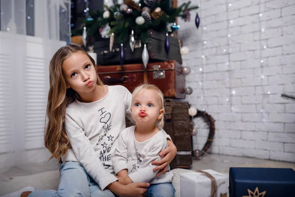 Bambini sotto l'albero di Natale con scatole regalo. Le decorazioni di anno nuovo . — Foto Stock