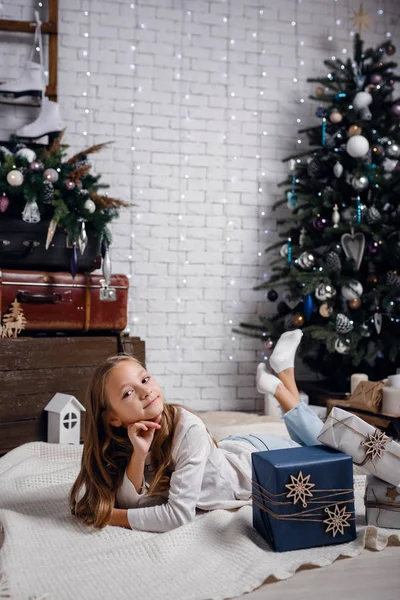 Bambini sotto l'albero di Natale con scatole regalo. Le decorazioni di anno nuovo . — Foto Stock