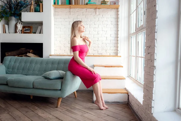 Mladá žena sedí na gauči — Stock fotografie