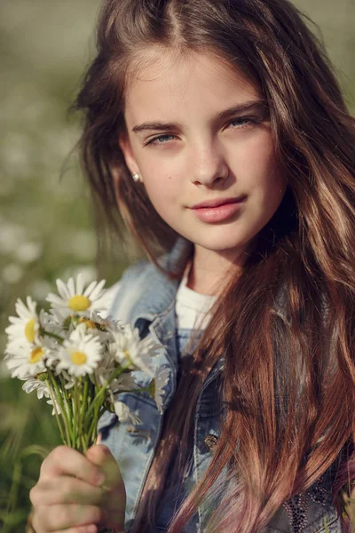 Маленькая девочка в поле ромашковых цветов — стоковое фото
