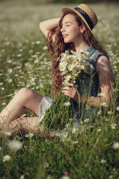 Menina em um campo de flores de margarida — Fotografia de Stock