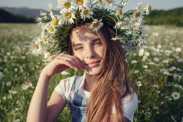 Маленькая девочка в поле ромашковых цветов — стоковое фото