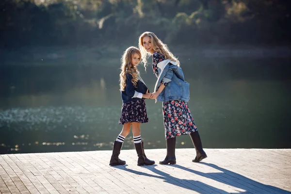 Hermosa chica elegante amigos cerca de un lago de montaña en el bosque —  Fotos de Stock