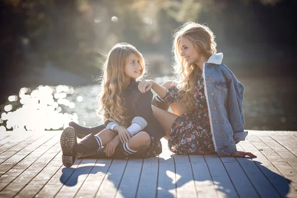 Beautiful stylish girl friends near a mountain lake in the forest — Stock Photo, Image