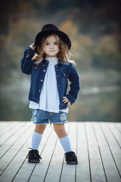 Retrato de queda ao ar livre da menina com chapéu e jeans desgaste . — Fotografia de Stock